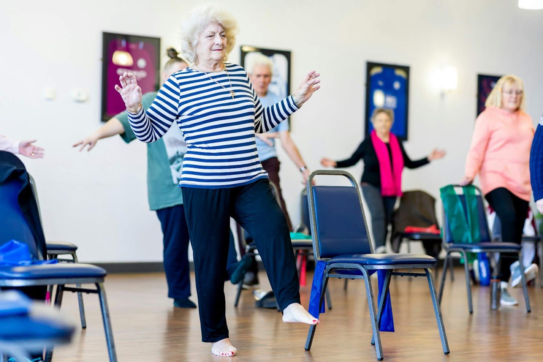Older adults following a movement class in a bright community room
