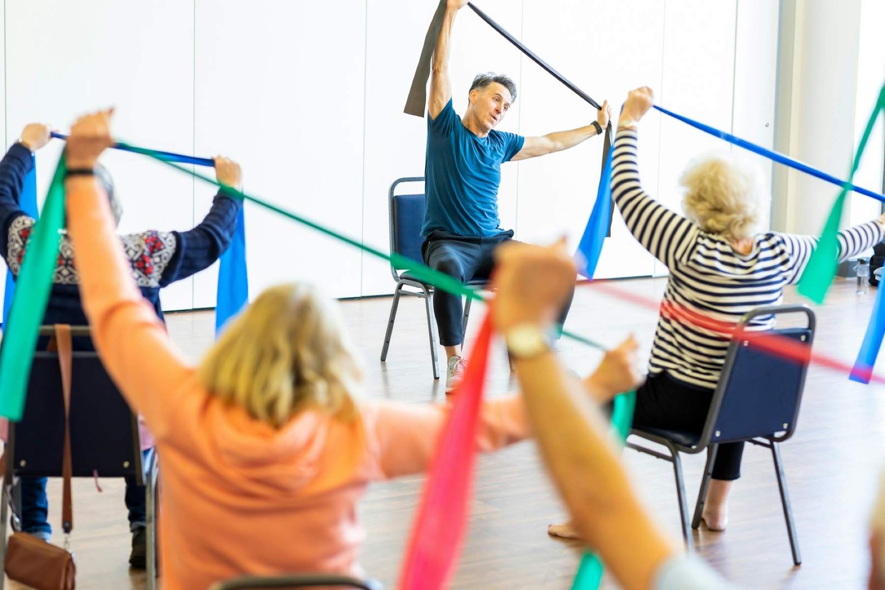 Seated group class stretching resistance bands overhead