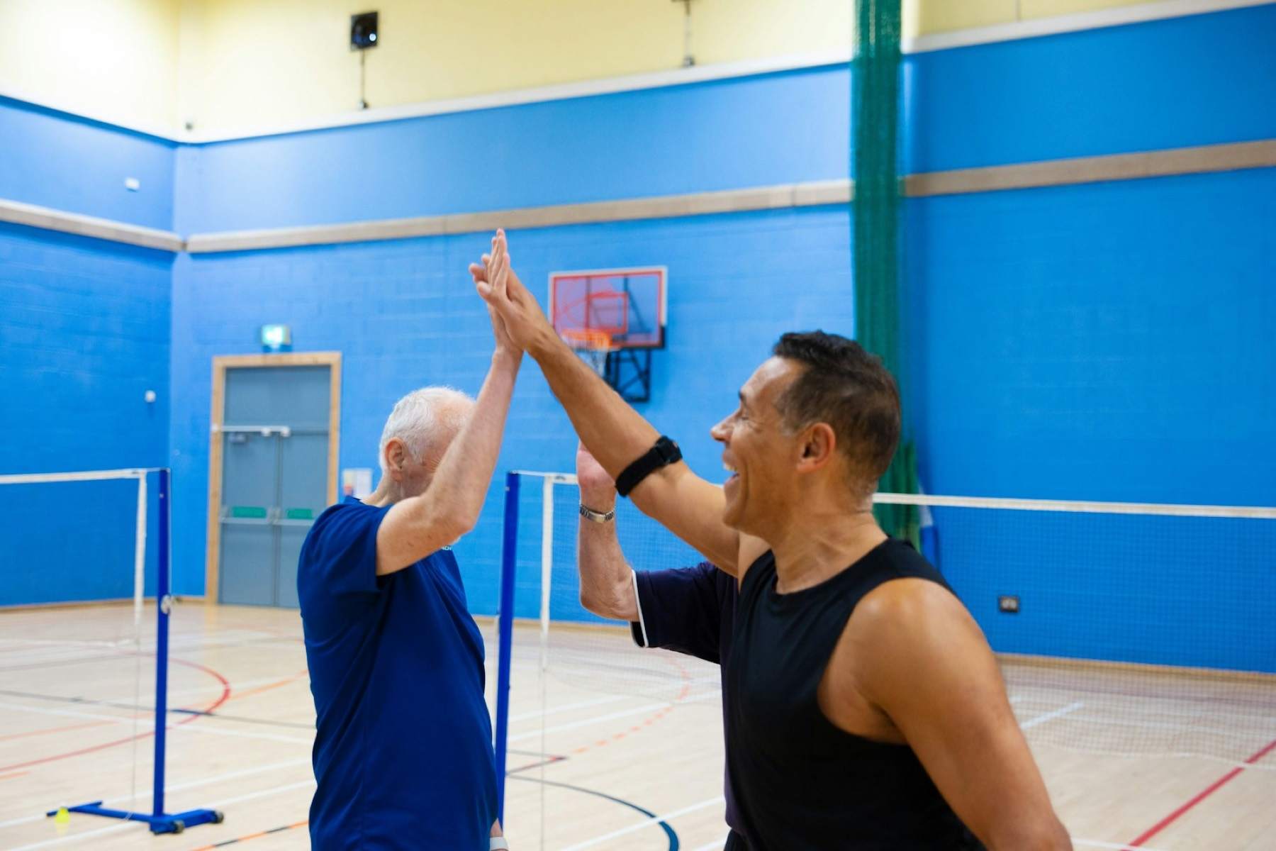 A trainer and an older client sharing a high five after a session